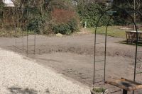 Het moestuingedeelte is gevuld; de rozenbogen staan